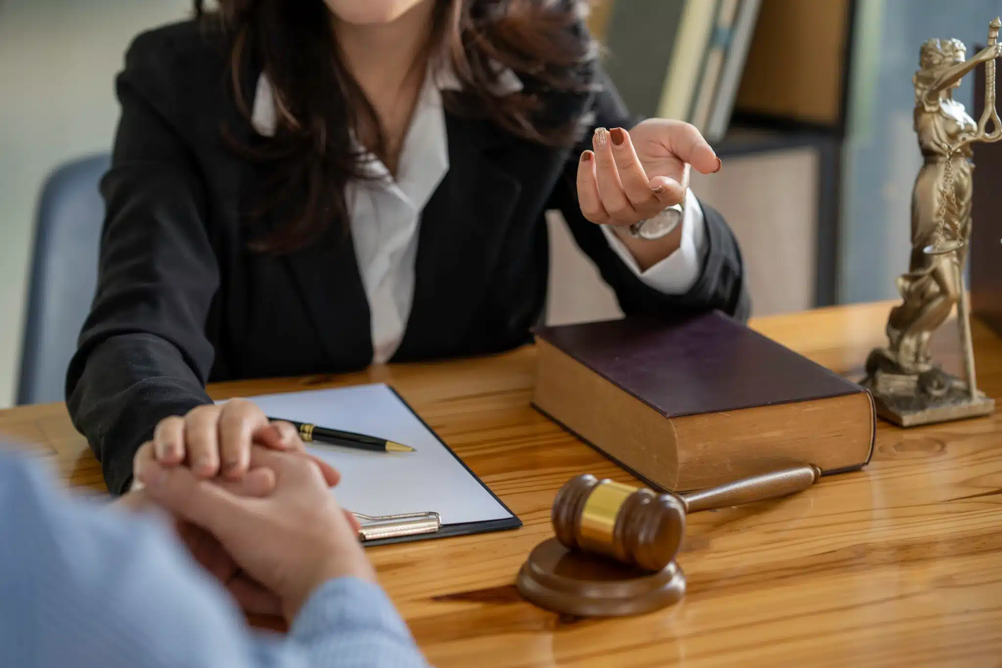 Lawyer consulting client with gavel and law book