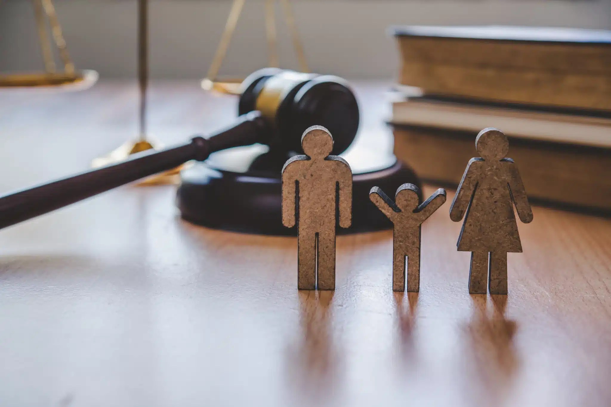 Wooden family figures before judge gavel and scales
