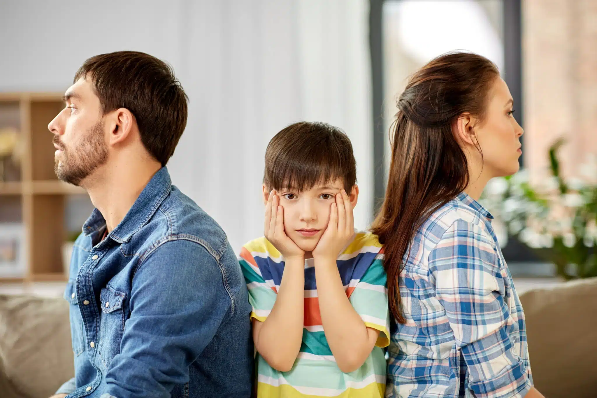 Upset child between arguing parents at home