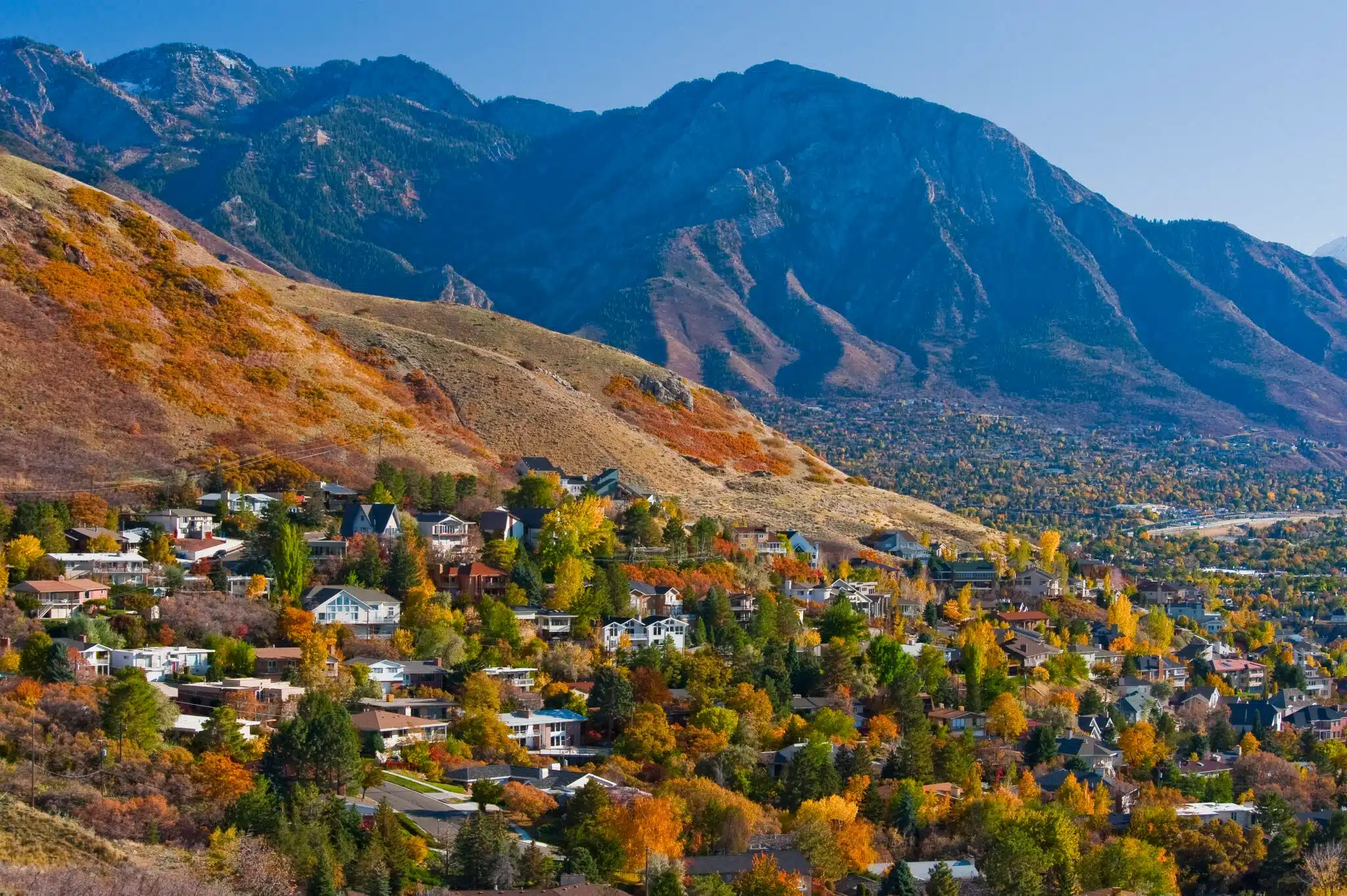 Autumn neighborhood beneath towering mountain range