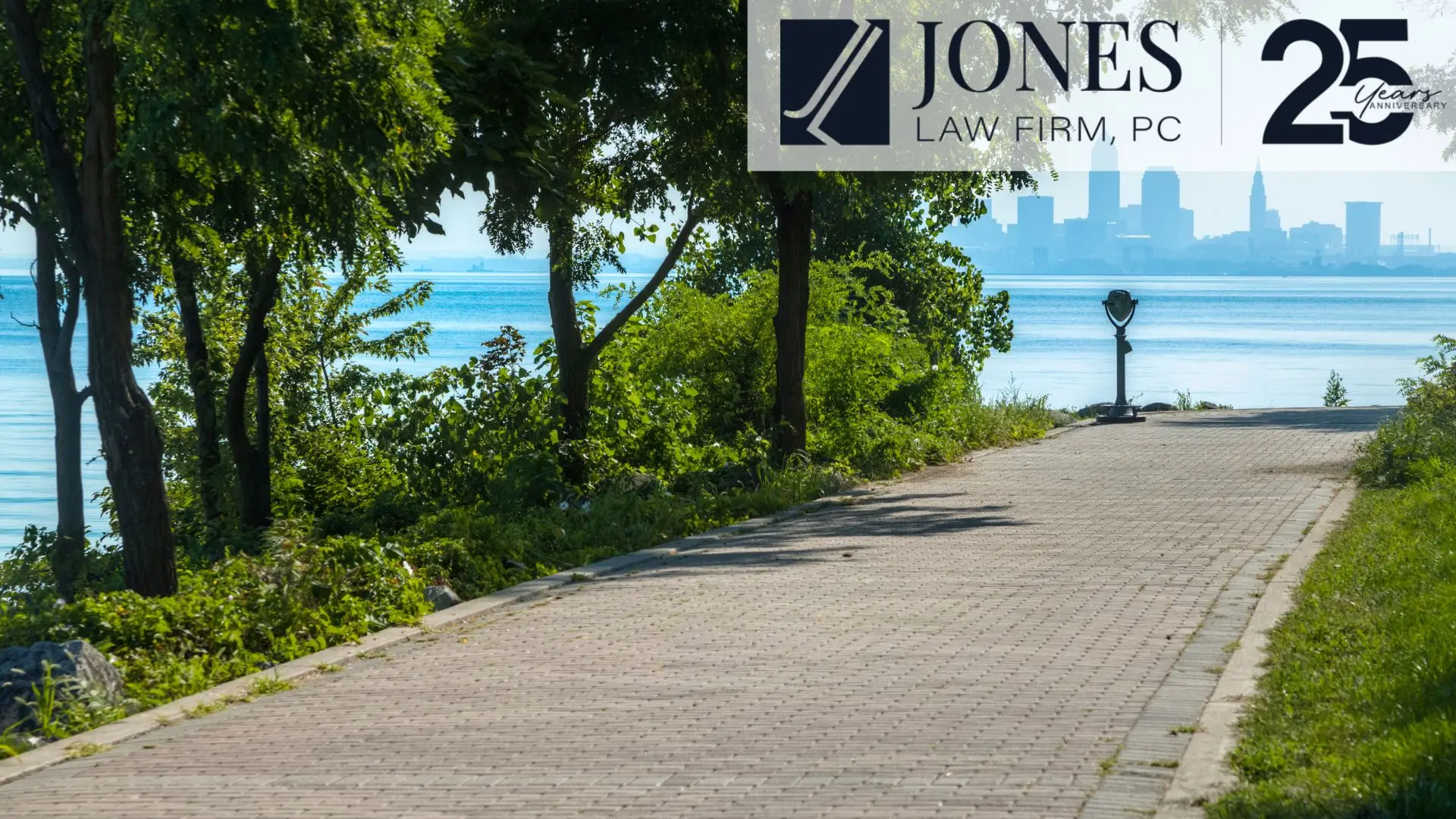 Riverside walkway with city skyline and law firm banner
