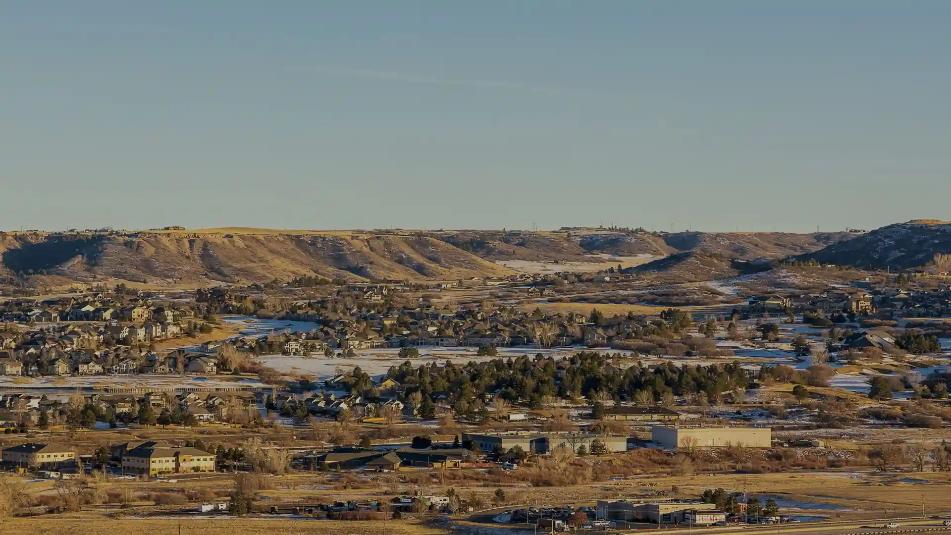 Suburban neighborhood in valley with snow-dusted hills in parker colorado
