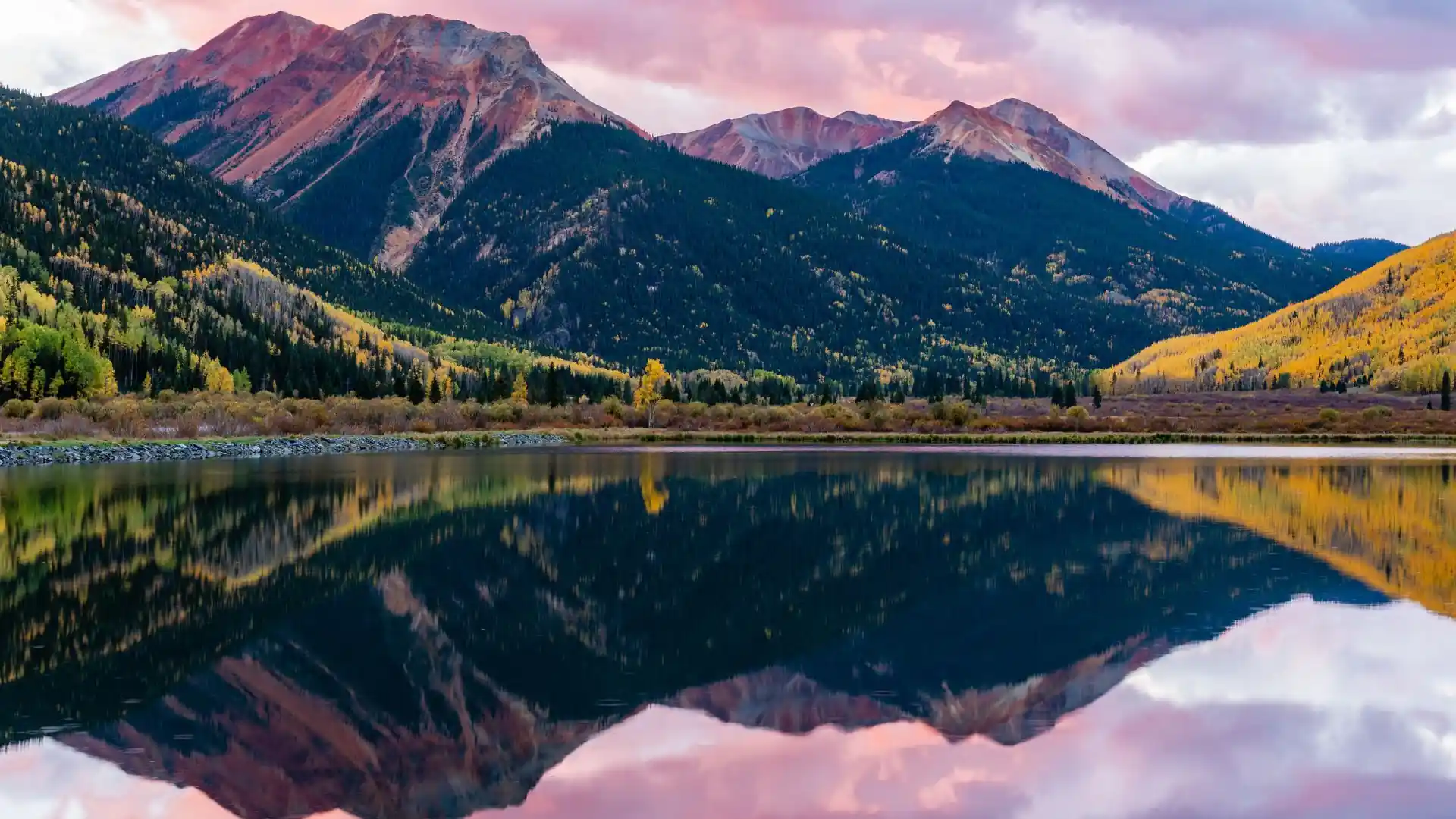 Mountain landscape reflected in calm autumn lake in Colorado