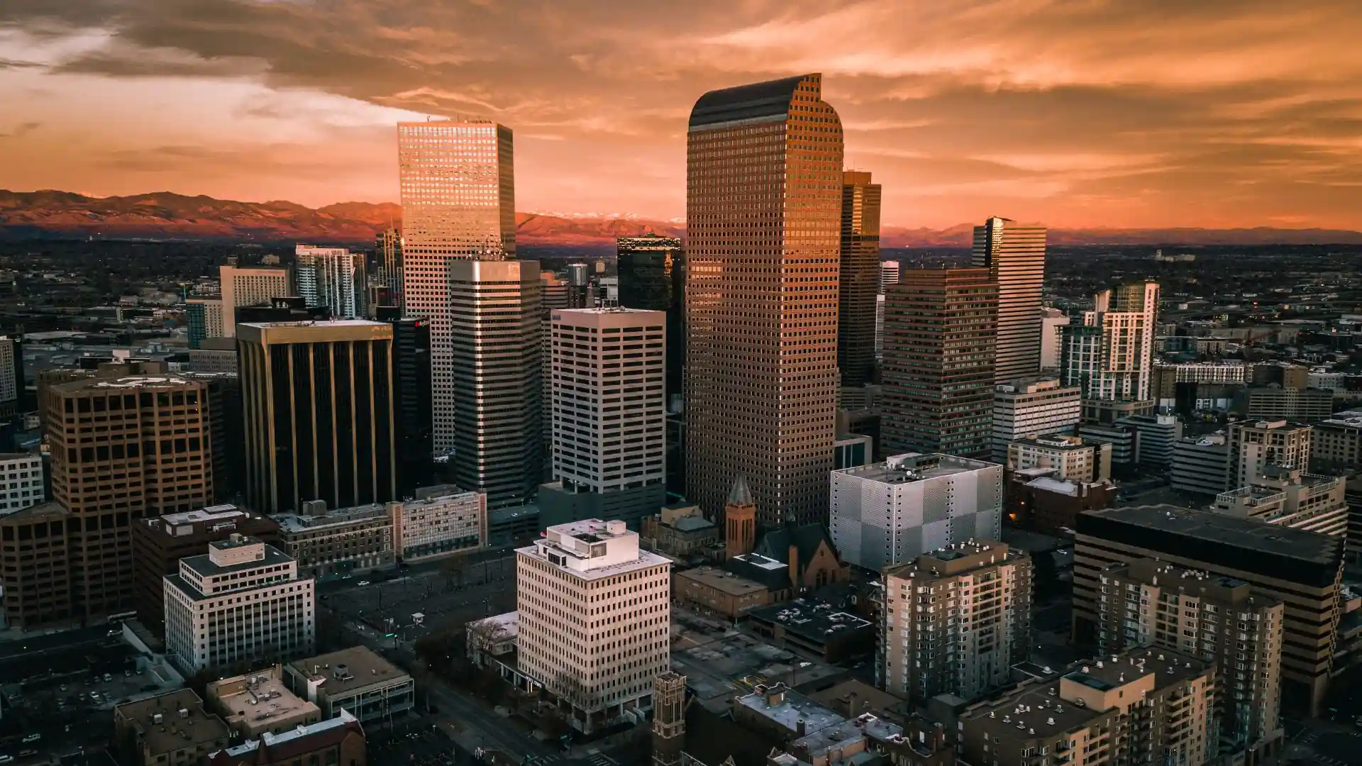 Denver skyline at sunset with Rocky Mountains