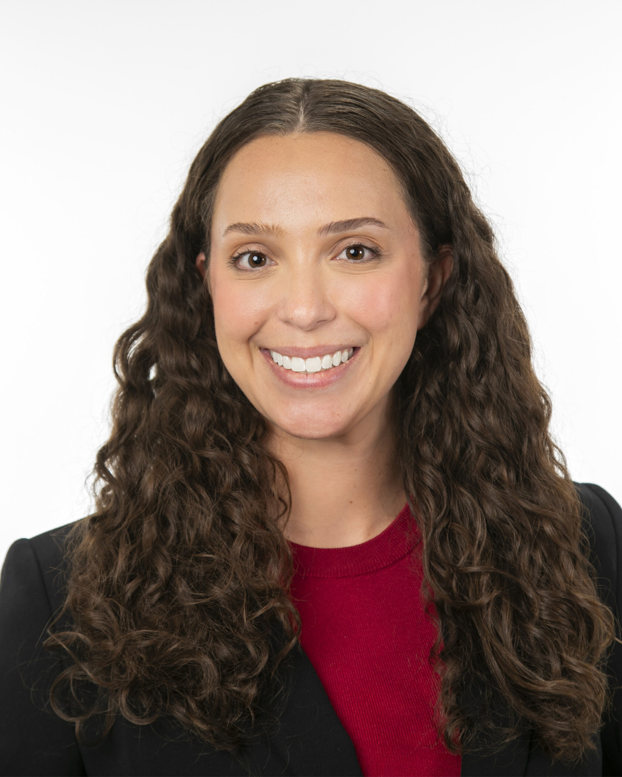 Smiling woman in black blazer and red top