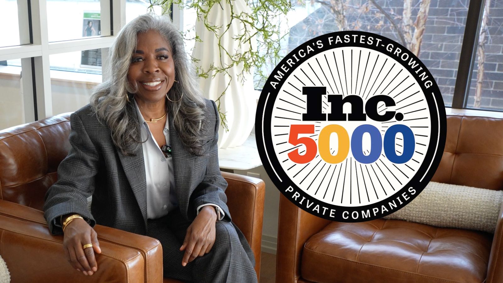 Businesswoman seated beside Inc. 5000 award graphic